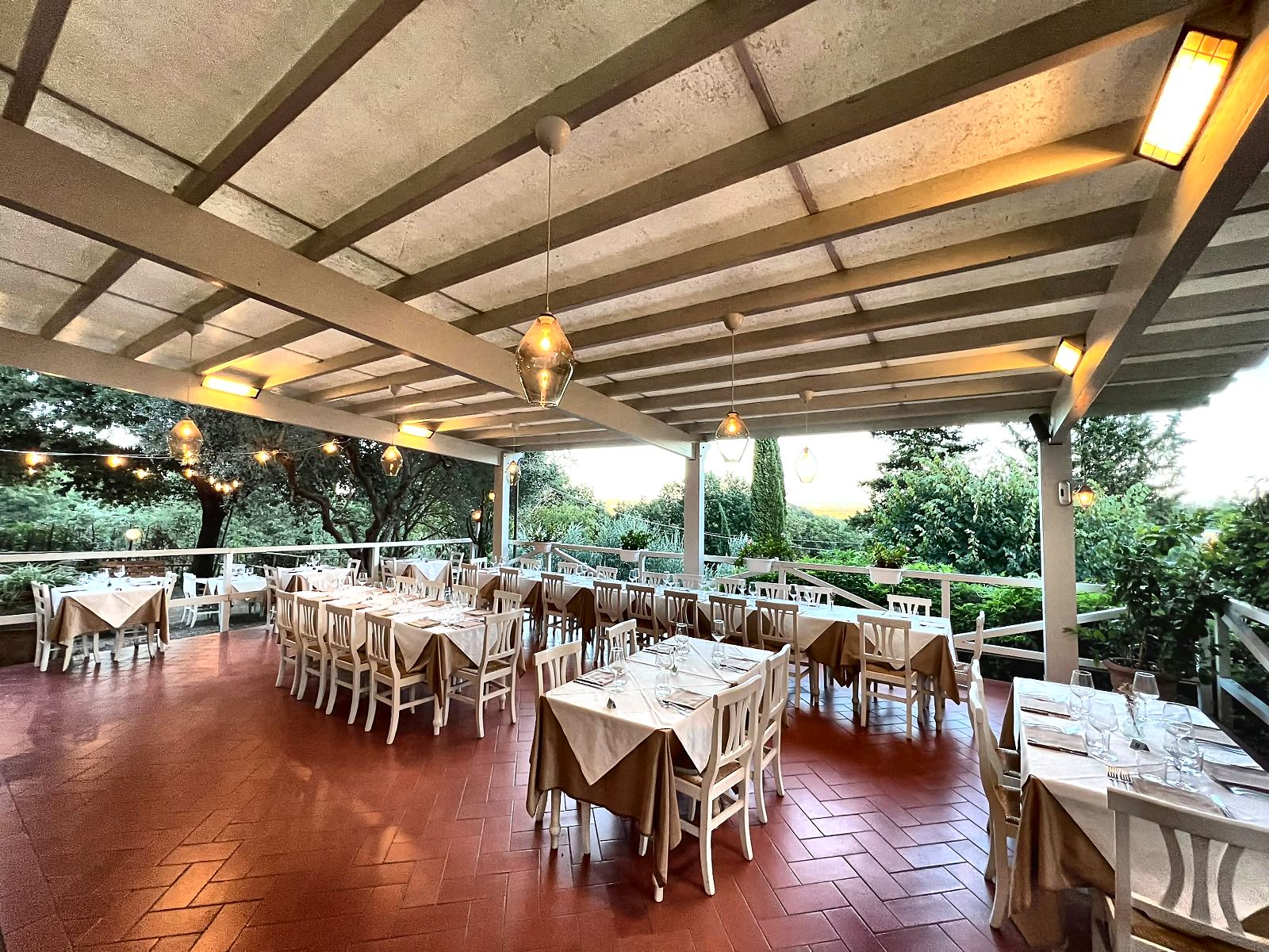 Tavoli pronti in terrazza sotto il pergolato